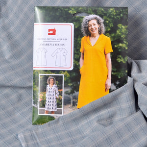 A sewing pattern package for the Amarena Dress shown with yarn dyed cotton fabric
