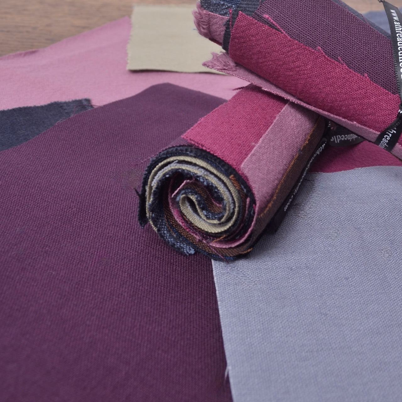 An assortment of  cotton fabric pieces selected for visible mending, sashiko patches, stitch books, and other hand-stitching projects.