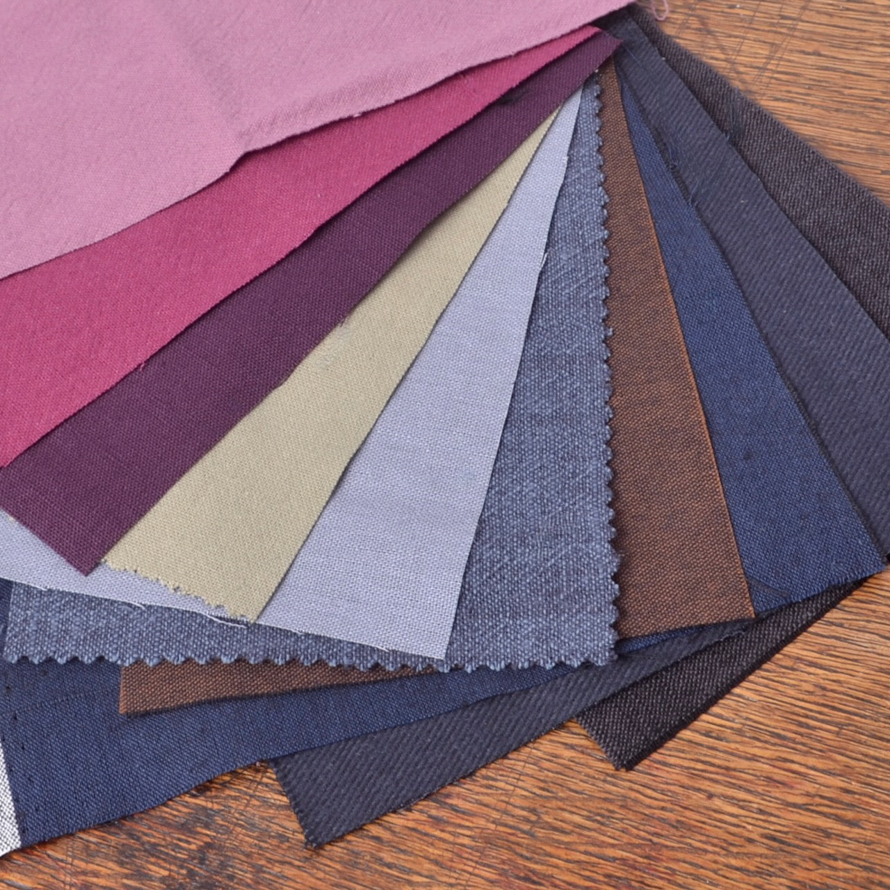 A mixed assortment of solid-colour cotton fabric pieces selected for visible mending