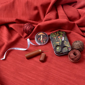 forest mushroom print on tape measure shown with other sewing notions and threads