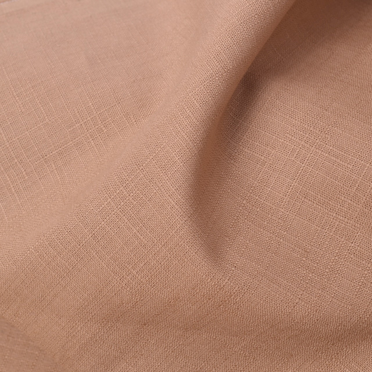 A close-up of draped dobby weave cotton fabric showing a subtle woven texture and soft folds.