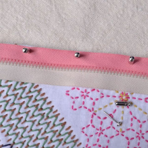 showing cap side of flat head purse pins holding zipper in place