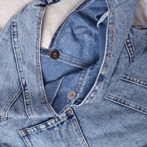 close up showing ietails of denim bag finishing and snap closure