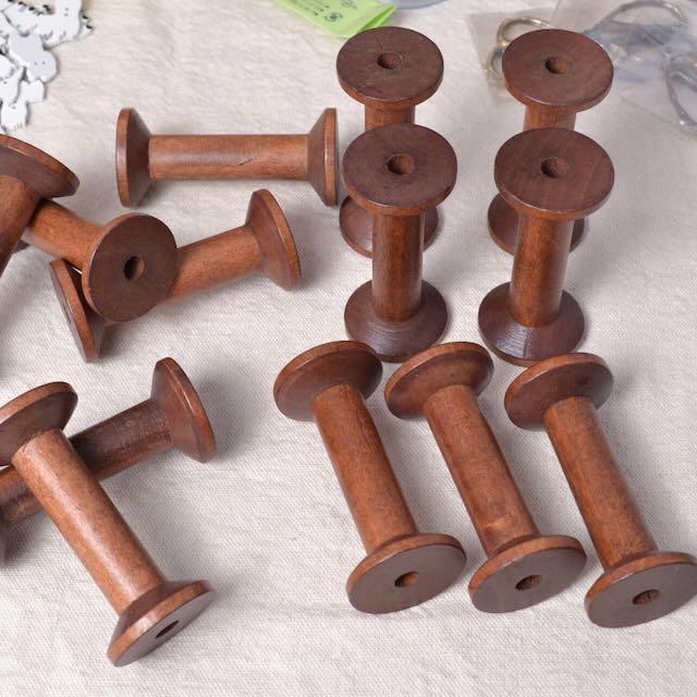 Set of wooden spools on a textured surface