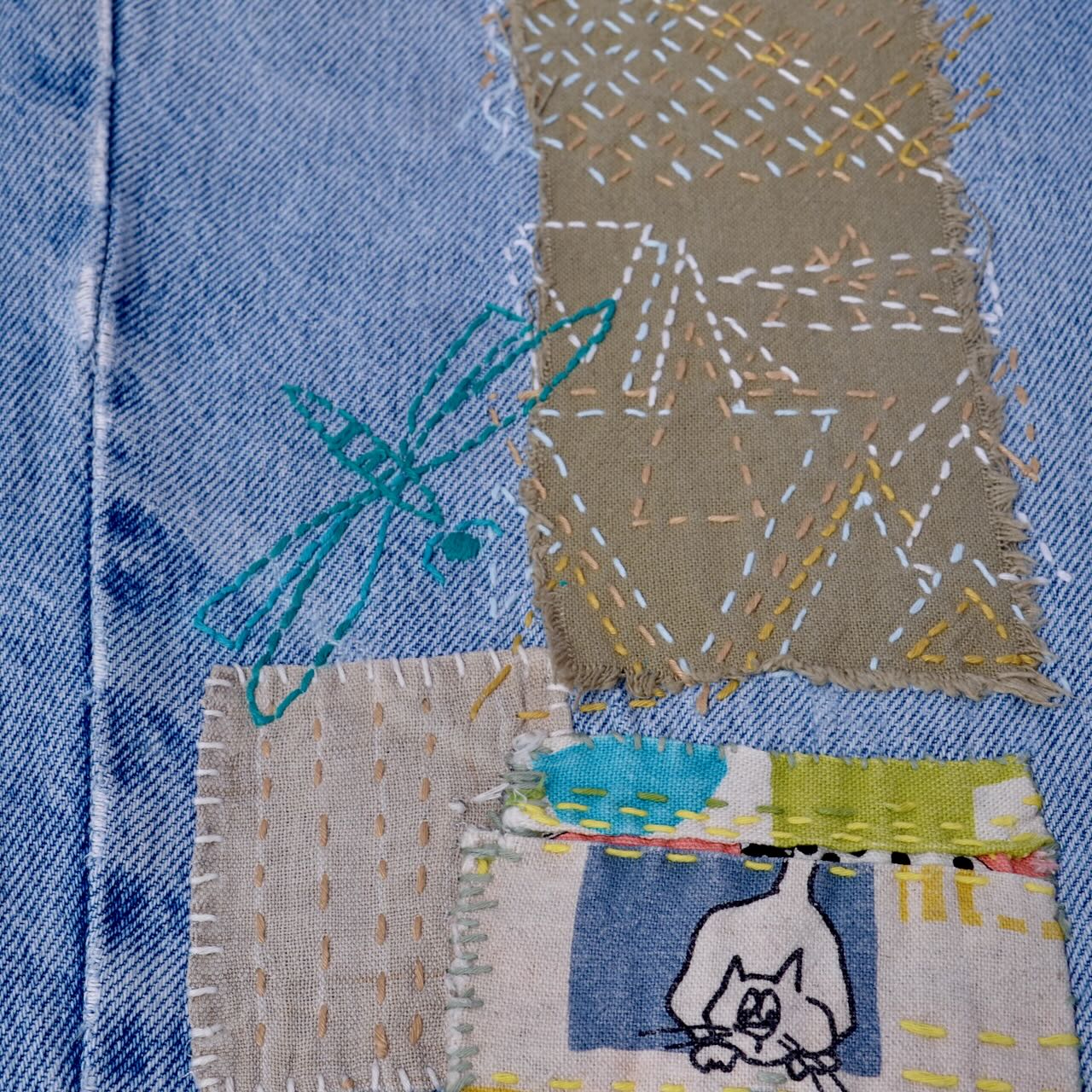 several stitched patched on blue jeans