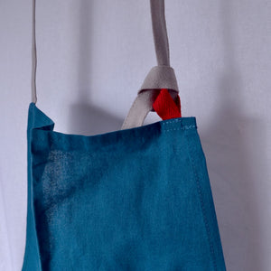 light cotton blue apron with taupe ties and red tags for kitchen and studio use