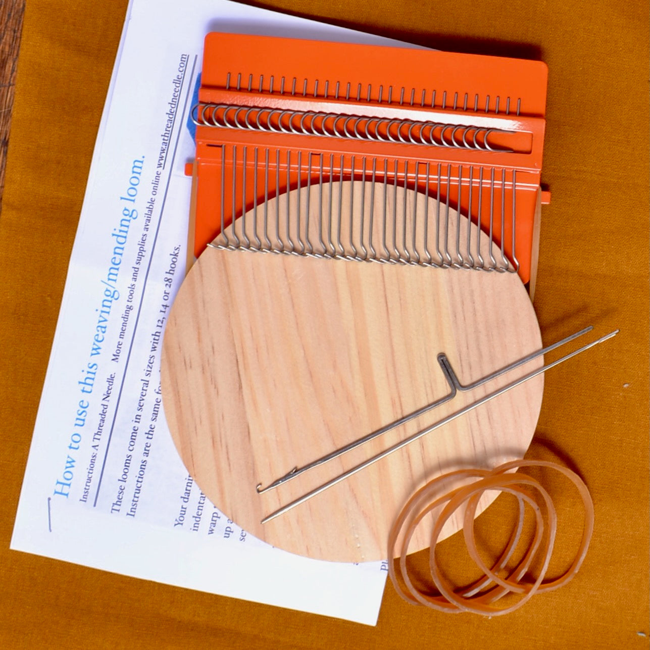 Orange coated metal mending loom  with wood weaving surface