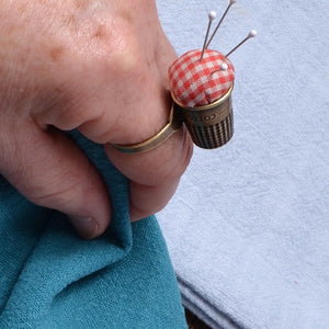 pin cushion right  on index finger, sewing notion