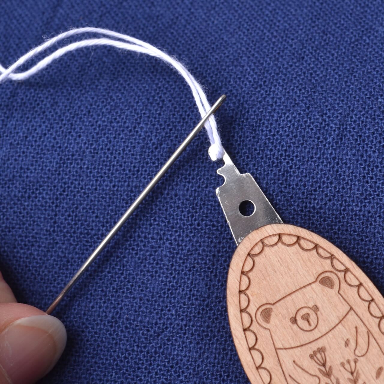 Needle Threader "Wood Bear" with needle being threaded