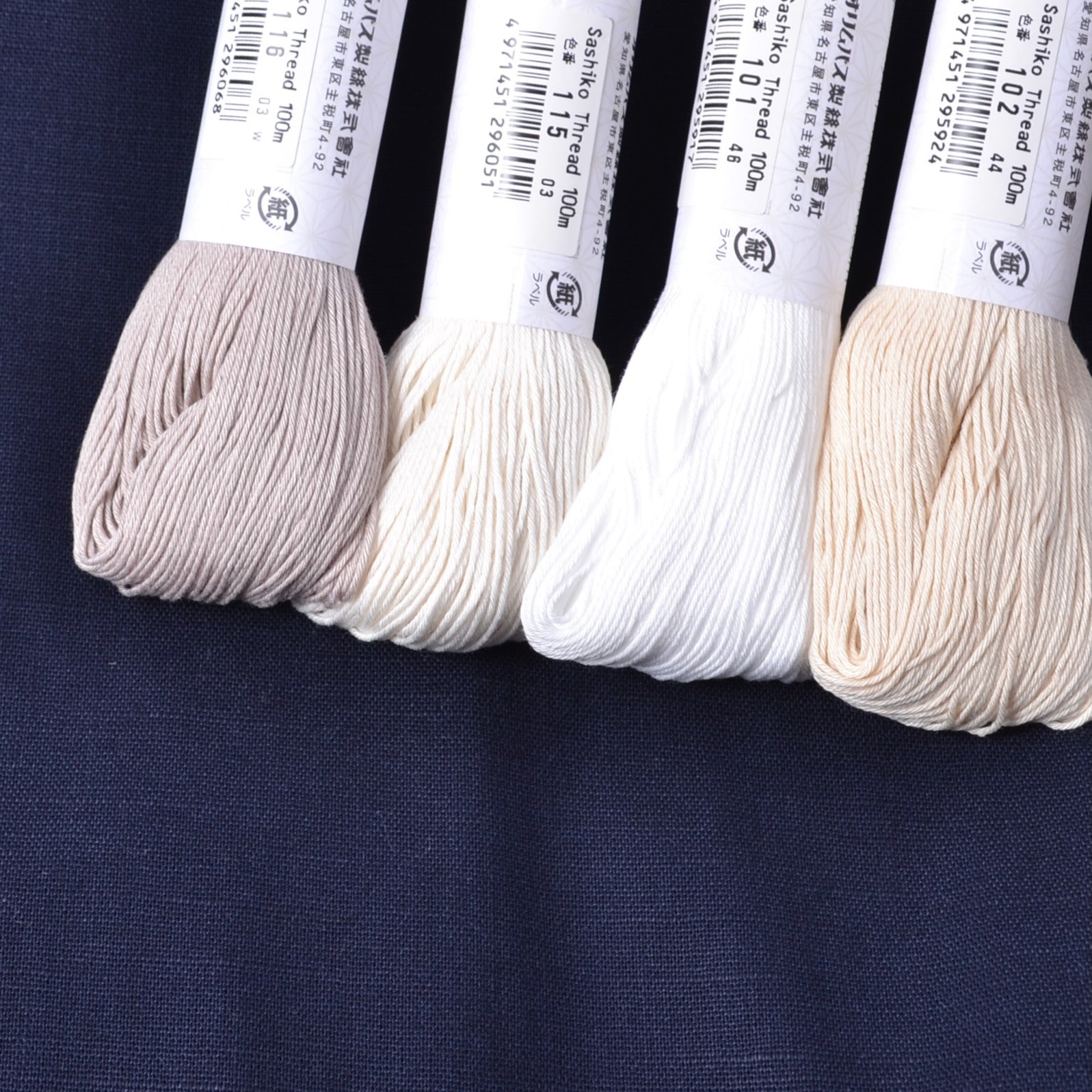 4 white sashiko threads compared on navy blue fabric