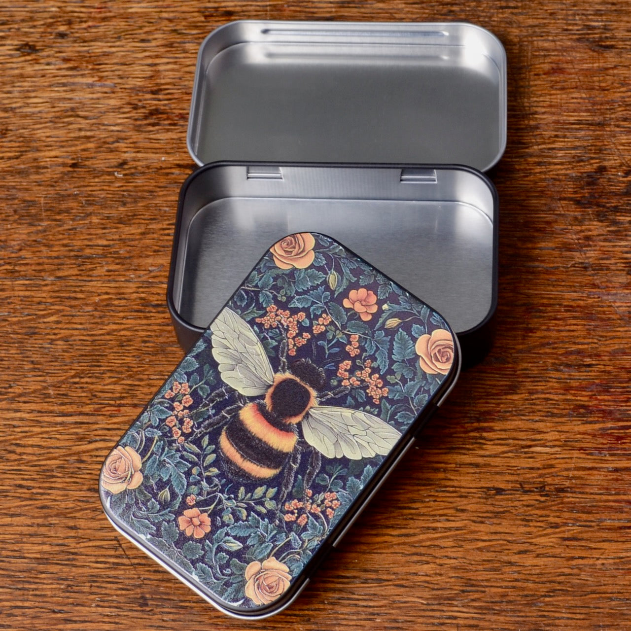 Metal tin with floral and bee design on the surface