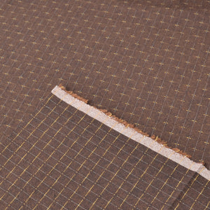 A close-up of a dark brown woven fabric with a fine grid pattern showing both sides of the fabric and the salvage