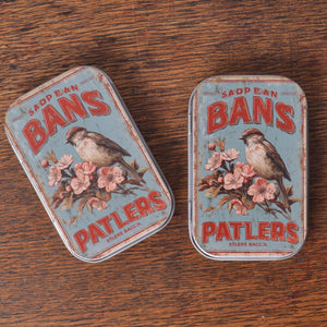 Two vintage-style tins with bird and floral design 