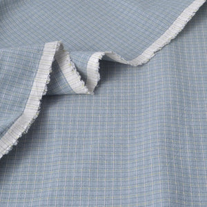 Light blue and white cotton fabric salvage edge to show texture and weave.