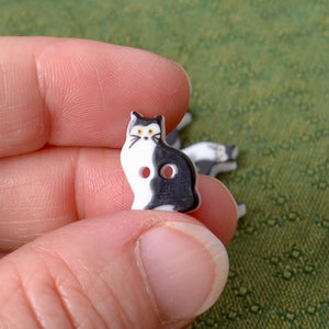 Small black and white cat-shaped button 
