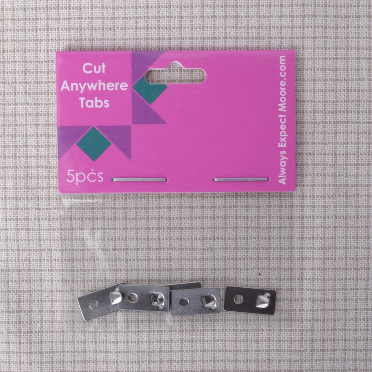 Packaging of 'Cut Anywhere Tabs' with metal tabs on a textured gray background