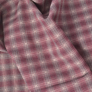 A close-up of draped yarn dyed cotton fabric with a dusty rose and white plaid pattern.