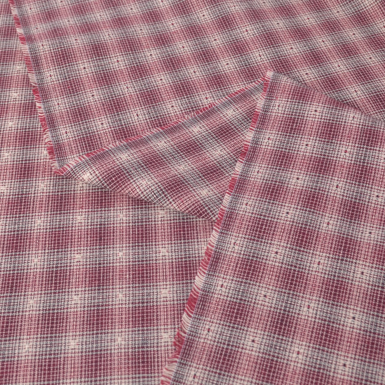 plaid yarn dyed cotton fabric with a dusty rose, red, and white pattern, showing both sides of the fabric