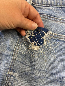 Close-up of a blue denim pocket with sashiko mending
