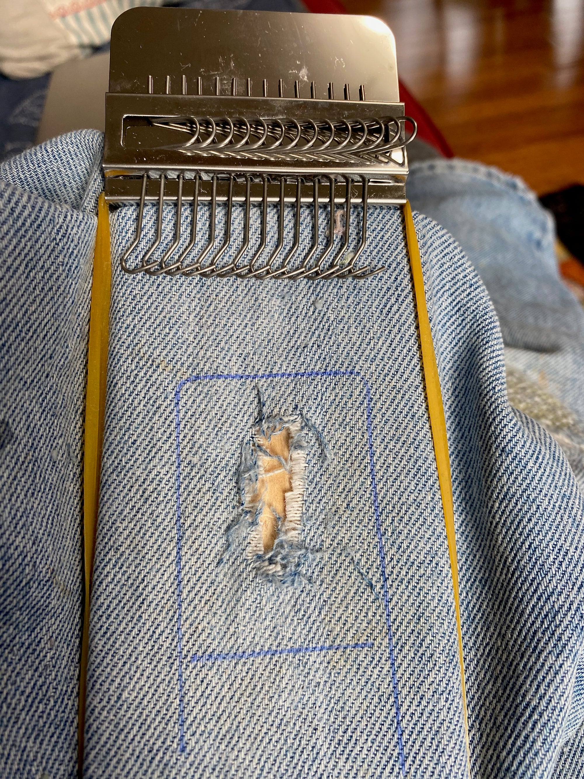 long speedweve style mending loom on  being used to repair blue jeans